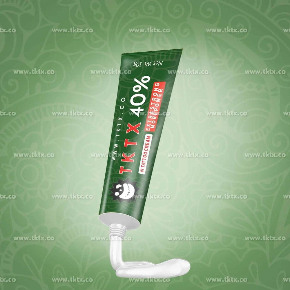 
                      
                        Green TKTX 40% numbing cream tube for tattoo and piercing pain relief on decorative background
                      
                    