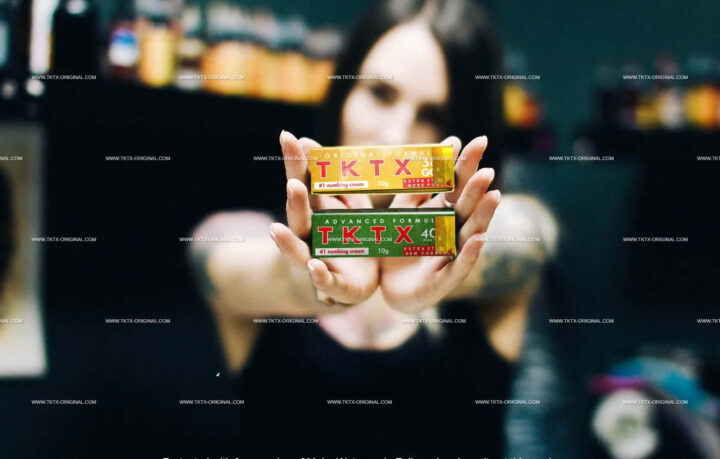 TKTX numbing tattoo cream displayed by person in tattoo studio